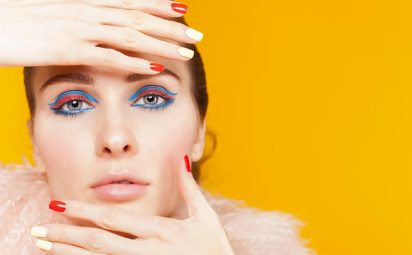 Experiment with eyeliner styles, like this woman's bright blue and pink eyeliner.