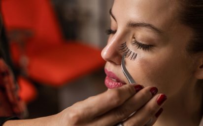 This woman is learning how to apply false eyelashes.