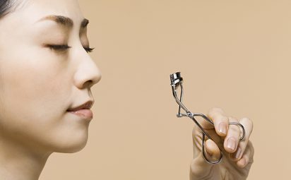Our tips will help you learn how to use an eyelash curler like this woman