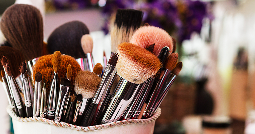 many used makeup brushes in a container