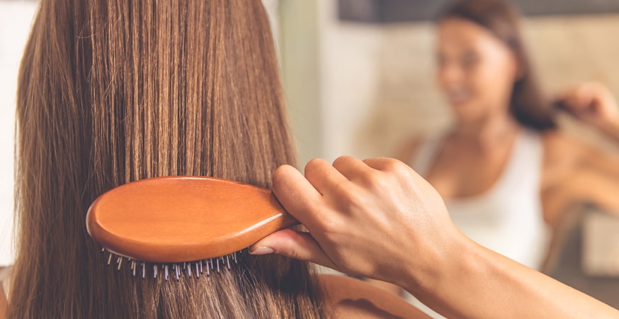 woman brushing hair how to straighten hair without heat