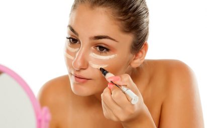 woman applying concealer to dark circles