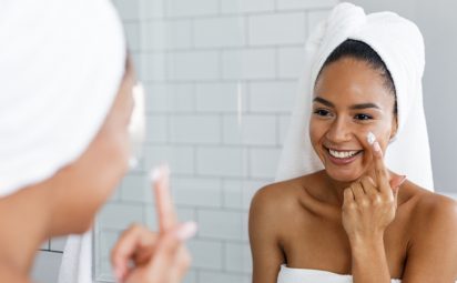 woman applying moisturizer to skin