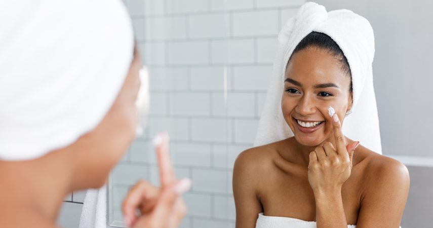 woman applying moisturizer to skin