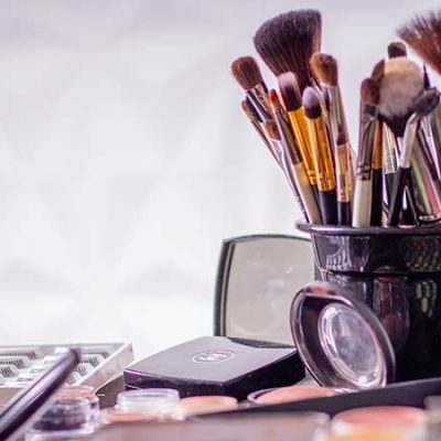 How to Use a Fan Brush A jar of makeup brushes, and makeup palettes