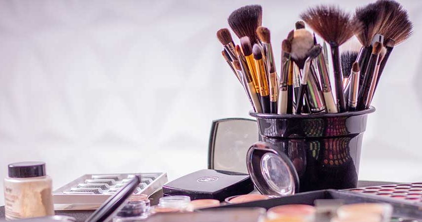 A jar of makeup brushes, and makeup palettes
