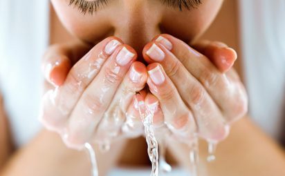 A woman is cleansing her face