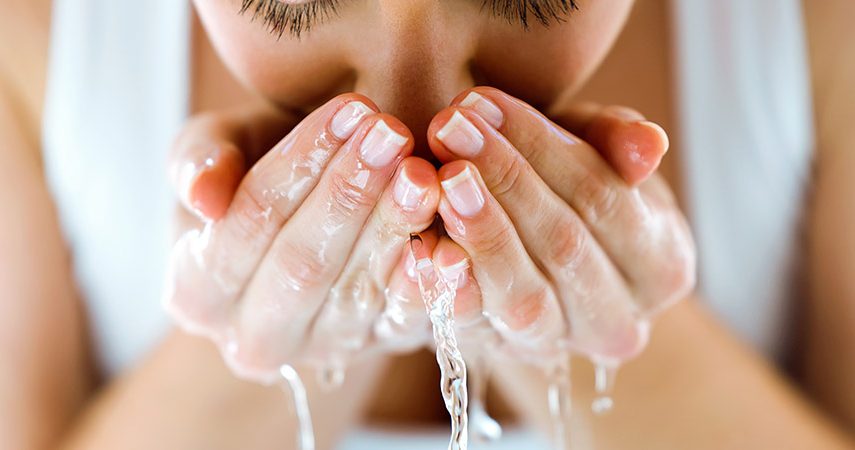 A woman is cleansing her face