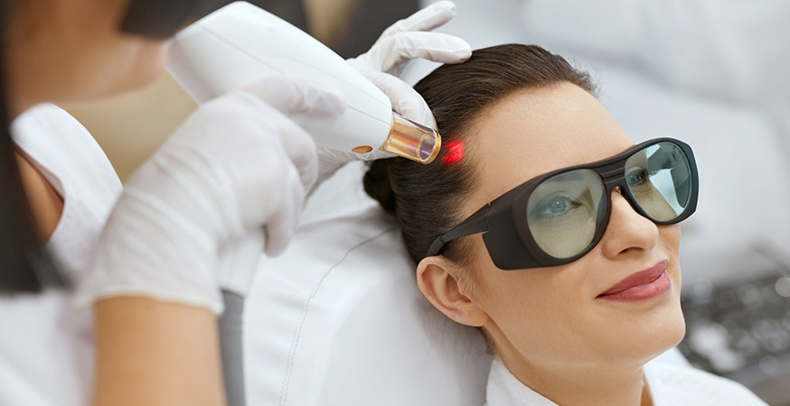 Woman receiving laser hair growth treatment