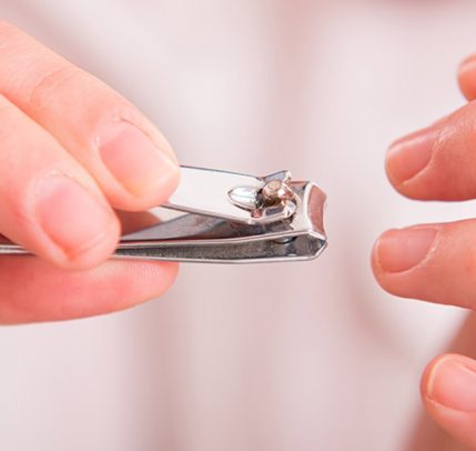 Three Easy Ways to Fix a Broken Nail at Home A woman is trimming her nails with a nail clipper