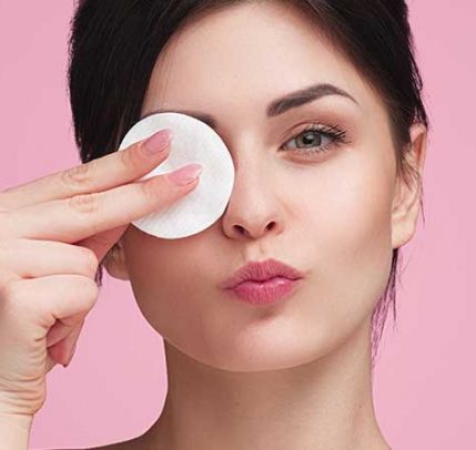 How to Remove Makeup A woman using a cotton pad to remove her makeup