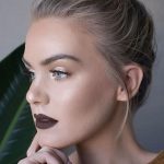 girl with blond hair and natural-looking makeup with dark purple lipstick