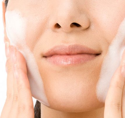 What to Look for and Avoid in a Cleanser for Sensitive Skin Woman is washing her face with a cleanser