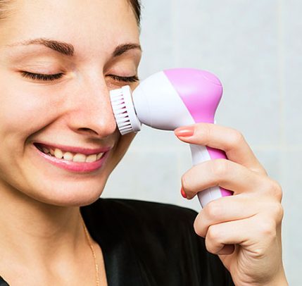 Woman using a facial cleansing brush