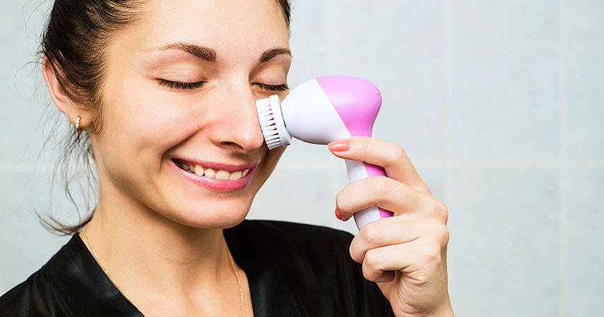 Woman using a facial cleansing brush