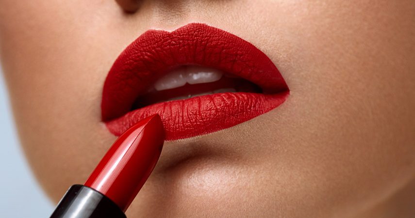Closeup of woman face with bright red matte lipstick on lips