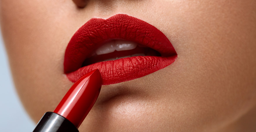 Closeup of woman face with bright red matte lipstick on lips