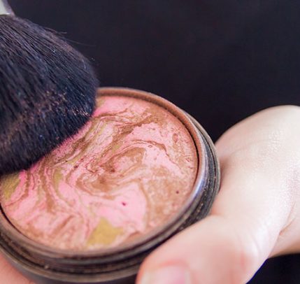 how-to-apply-bronzer Close up of woman hands holding makeup bronzer
