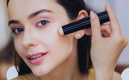 Woman using concealer stick