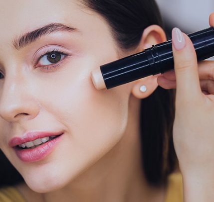 The Different Types of Concealer and Their Uses Woman using concealer stick