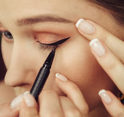 a woman applying black liquid eyeliner