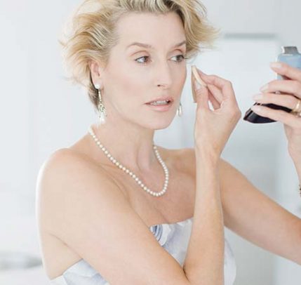 How To Use Powder Concealer mature woman applying makeup with a beauty sponge