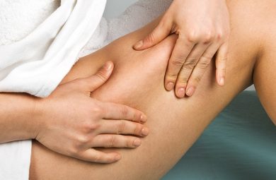 person pinching thigh for cellulite check