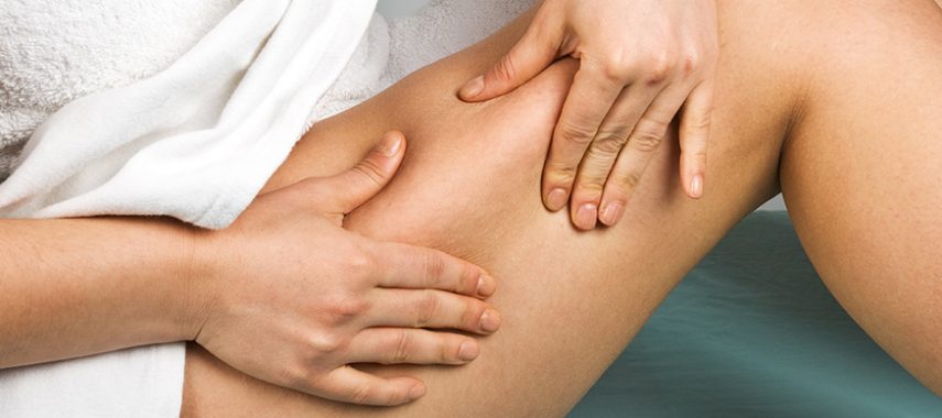 person pinching thigh for cellulite check