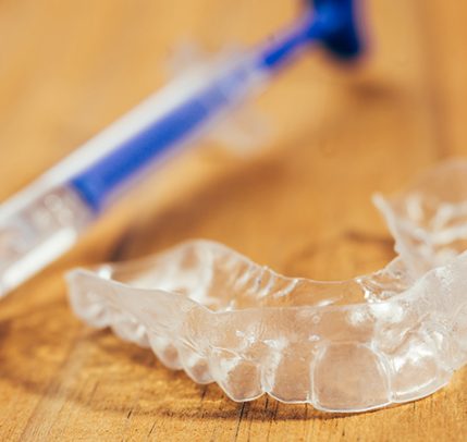Best At Home Teeth Whitening: From Whitening Kits to DIY Tricks Individual teeth tray for whitening on wooden background