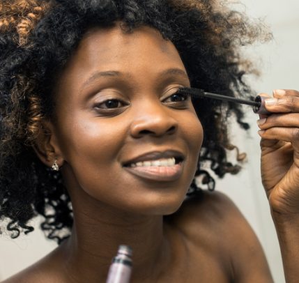 Basic Makeup Tutorial: How to Create a Simple Makeup Look black woman applying mascara in a mirror
