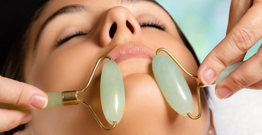 Somone is getting a jade facial roller treatment.