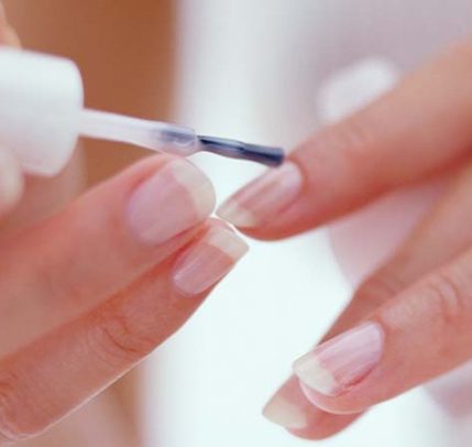 Nail growth treatment at home Someone applying nail growth nail polish to their nails.
