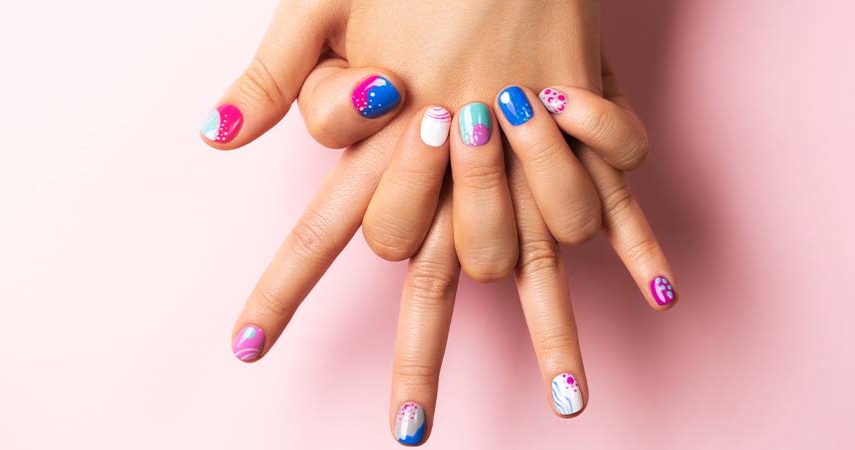 Someone showing summer nail designs against a pink background.