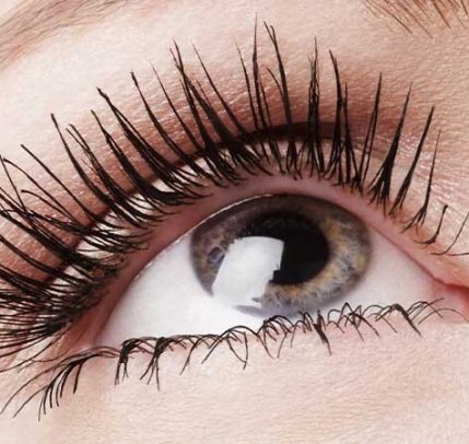 A close up photo of a person's eye and eye lashes wearing mascara