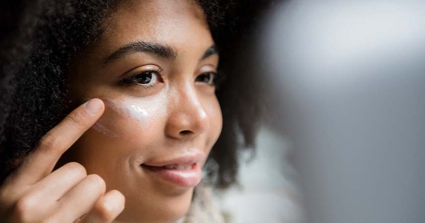 A woman applying eye cream.