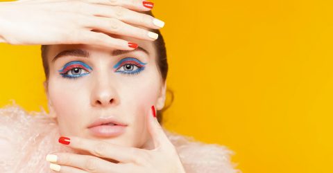 Experiment with eyeliner styles, like this woman's bright blue and pink eyeliner.